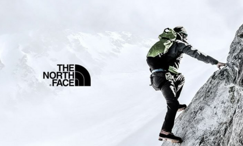 Wspinacz na zboczu stromej góry w odzieży matki THE NORTH FACE 